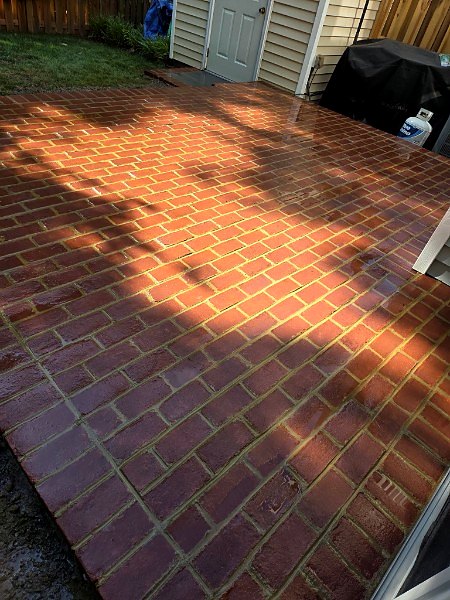 Red brick paver patio in warm evening light with dappled shade
