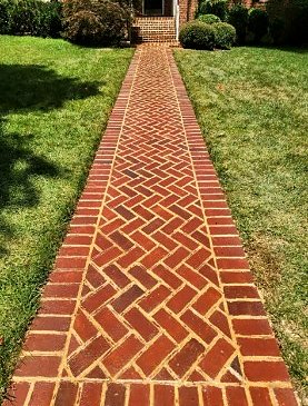 Red brick front walkway laid in herringbone with a soldier course border
